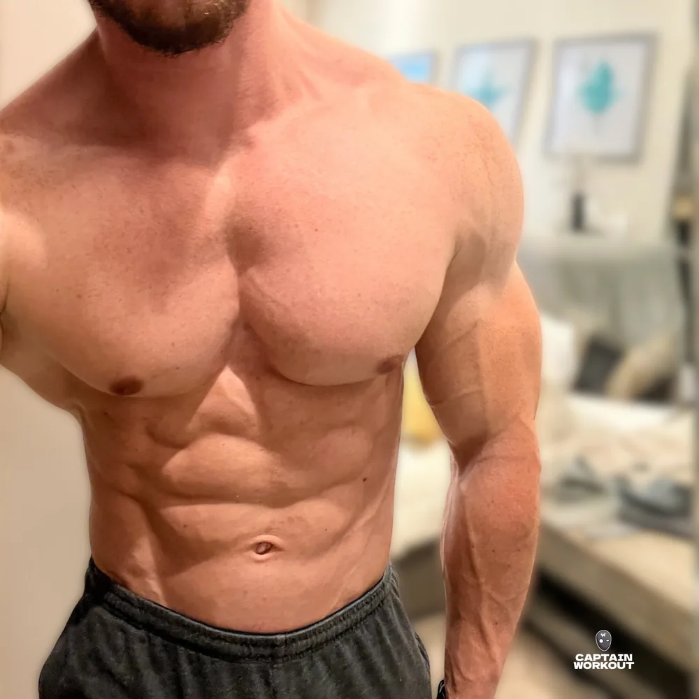 Captain Workout now: a broad, muscular chest, shoulders and arms with visible abs